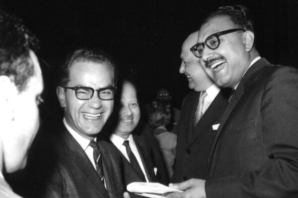 ICTP inauguration ceremony, 1964 Abdus Salam standing next to Mario Franzil and physicist G. Gerin. Everyone is smiling and laughing.
