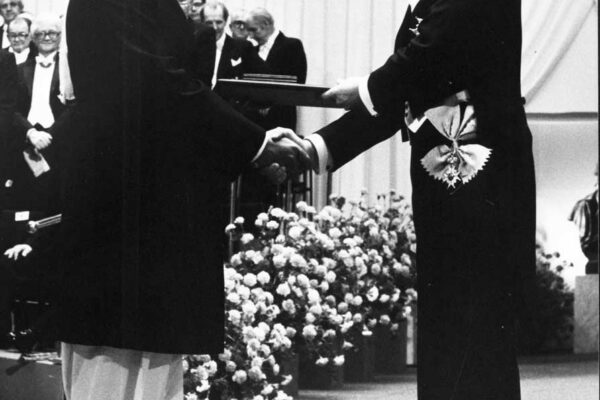 Nobel Prize ceremony, 1979 Abdus Salam being awarded the Nobel Prize in Physics by King Carl XVI Gustaf. He shakes the King's hand as he receives a certificate on stage. He is dressed in a shervani and turban.
