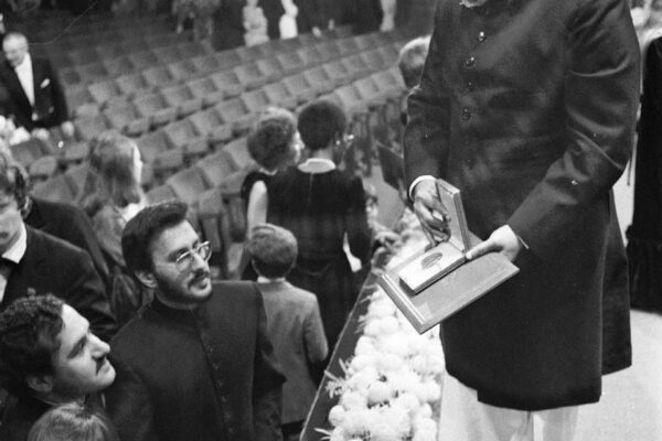 Nobel Prize ceremony, 1979 Abdus Salam showing the Nobel Prize medal to his family. He opens the box, displaying the medal inside, as others are exiting the award hall. Salam is standing on the stage, as his family crowd around him to see the medal.